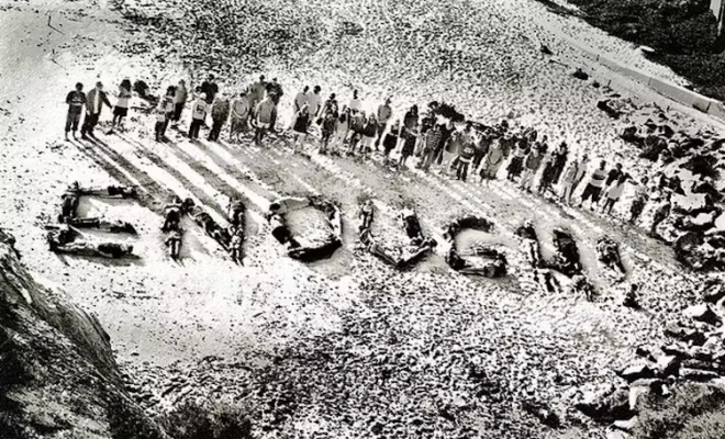 People laying down protesting against genocide spell out the word "Enough".