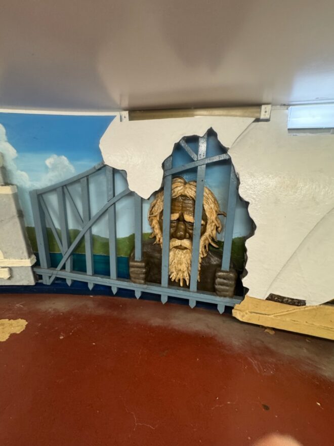 segment of an artwork at the entrance to Sydney's Domain Carpark. Sad-faced elderly Aboriginal man clutching the bars of the Sydney Harbour Bridge.