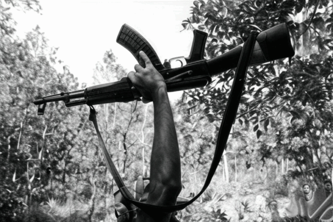 A raised arm holding aloft a weapon.
