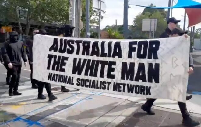 Neo-Nazi's marching with a sign, "Australia for the White Man, National Socialist Network."