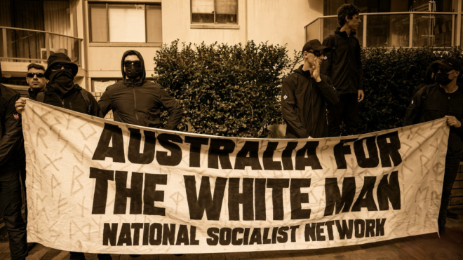 Masked men holding a banner, "Australia for the white man, National Socialist Network."